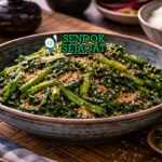 Goma-ae khas Jepang dengan sayur hijau renyah dibalut saus wijen gurih manis, disajikan dingin di piring putih sebagai pendamping nasi