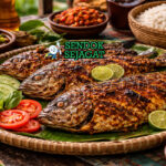 Ikan Baronang Bakar Siap Sajian dengan Renyah Menggoda Ikan baronang bakar khas Makassar dengan ikan utuh renyah keemasan berbalut bumbu kuning, disajikan hangat di piring bersama sambal colo-colo dan nasi putih