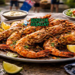 King Prawns on the Barbie Siap Sajian dengan Aroma Asap Menggoda King Prawns on the Barbie khas Australia dengan udang besar panggang keemasan oles garlic butter, disajikan hangat di piring bersama irisan lemon dan peterseli