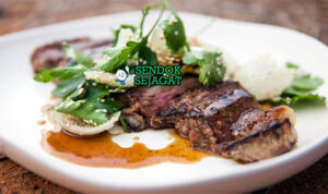 Pepperberry Beef Steak khas Australia dengan daging sapi panggang juicy kecokelatan, taburan pepperberry pedas fruity, tampak gurih hangat menggugah selera