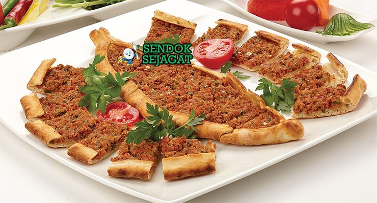Pide khas Turki berbentuk perahu dengan pinggir renyah emas, isi daging cincang tomat bawang gurih, tampak hangat menggugah selera