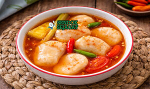 Pindang Kemplang khas Palembang dengan kemplang lembut menyerap kuah asam segar kuning, tampak gurih hangat menggugah selera