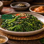 Sigeumchi Namul khas Korea dengan bayam hijau cerah dibalut saus wijen gurih, disajikan dingin di mangkuk putih sebagai banchan