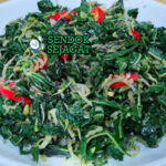 Tumis Daun Singkong khas Indonesia dengan daun singkong lembut, terasi gurih, cabai rawit banyak, tampak segar pedas menggugah selera
