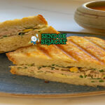 Tuna Melt Siap Nikmati Panas Tuna Melt khas Amerika dengan roti panggang renyah, isian tuna mayo creamy, keju cheddar leleh meluber, tampak gurih hangat menggugah selera