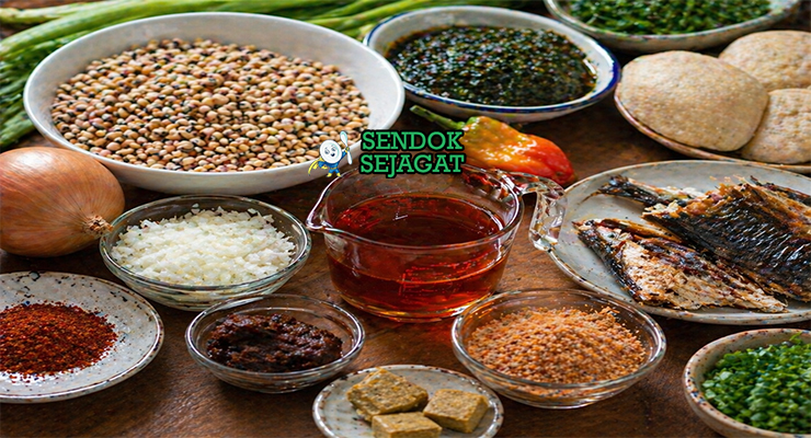 Tumpukan kacang cokelat kering, minyak kelapa sawit, iru fermentasi, udang kering, bawang, dan cabai segar siap untuk resep gbegiri