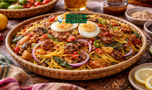 Piring abacha khas Nigeria berisi serpihan singkong renyah berbalut minyak kelapa sawit, ugba, ikan kering, bawang, dan daun utazi yang menggugah selera