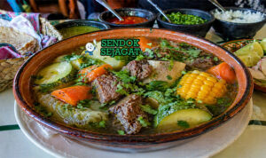 Sup bening dengan potongan daging sapi, jagung, wortel, kentang, dan zucchini dalam mangkuk hangat