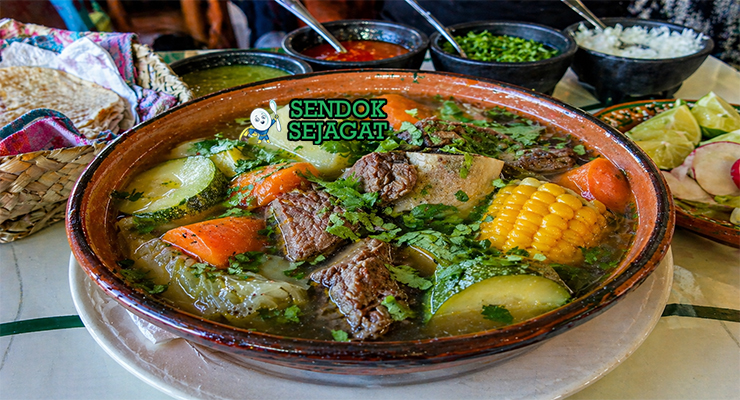 Sup bening dengan potongan daging sapi, jagung, wortel, kentang, dan zucchini dalam mangkuk hangat