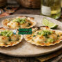 Coquilles St Jacques with Native Lime khas Australia dengan kerang panggang dalam cangkang, saus creamy, native lime pearls, dan taburan peterseli disajikan di piring putih
