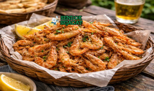 Fried school prawns khas Australia dengan udang kecil goreng renyah keemasan, ditaburi garam laut dan disajikan dengan lemon wedges di piring putih