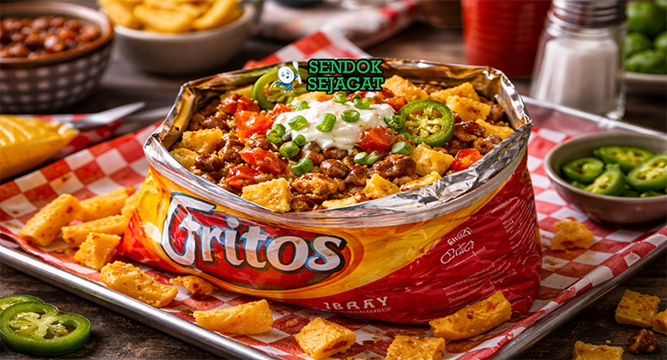 Frito Pie khas Amerika Serikat dengan keripik jagung Fritos disiram chili daging, keju cheddar meleleh, dan bawang cincang, disajikan hangat di mangkuk