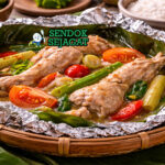 Hidangan garang asem ayam Jawa Tengah autentik dengan potongan ayam empuk, kuah santan bening asam segar, irisan belimbing wuluh dan cabe rawit di mangkuk tanah liat yang menggugah selera