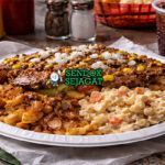 Garbage Plate khas Rochester dengan macaroni salad, home fries, daging cincang, dan meat sauce disiram di atas Fritos, ditaburi bawang dan mustard