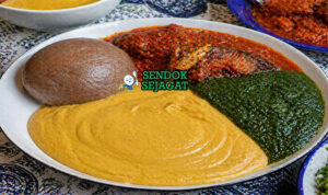 Mangkuk gbegiri sup kacang Nigeria berwarna cerah dari minyak sawit, disajikan hangat dengan tekstur kental menggugah selera