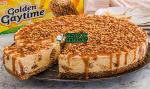 Cheesecake berlapis krim dengan topping karamel dan remah biskuit renyah berwarna keemasan