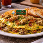 Hangtown Fry khas California dengan omelette tebal berisi oyster juicy, bacon renyah, dan bawang, disajikan hangat di piring