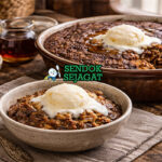 Indian pudding khas New England dengan tekstur creamy kuning keemasan, lapisan atas karamel, disajikan hangat di mangkuk dengan es krim vanila