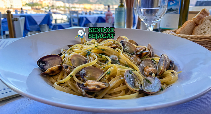 Pasta linguine dengan kerang bercangkang terbuka, minyak zaitun berkilau, taburan parsley hijau, dan tampilan elegan sederhana