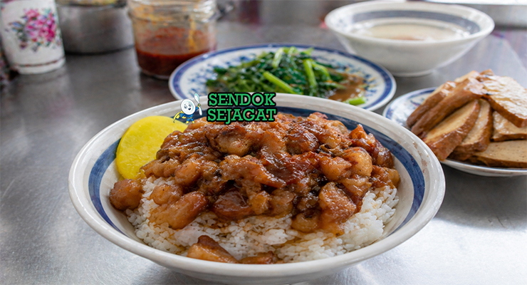 Semangkuk nasi putih hangat dengan topping daging babi cincang berkuah cokelat pekat dan telur rebus kecap yang mengilap