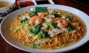 Mie goreng kering khas Makassar dengan tekstur renyah disiram kuah kental berwarna cokelat keemasan, berisi seafood dan sayuran segar