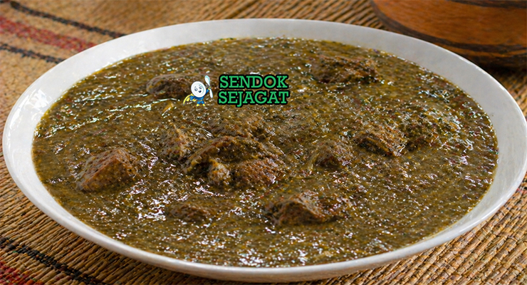 Sup berwarna hijau kecokelatan dengan potongan daging dan tekstur kental khas daun baobab