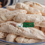 Kue almond berwarna putih keemasan dengan permukaan retak khas dan bentuk rustic