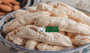 Kue almond berwarna putih keemasan dengan permukaan retak khas dan bentuk rustic