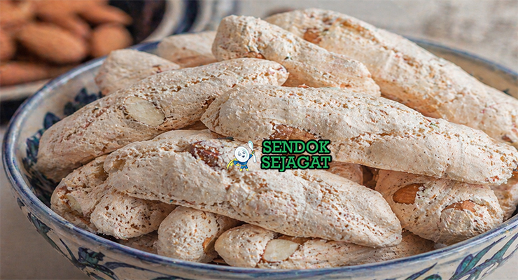 Kue almond berwarna putih keemasan dengan permukaan retak khas dan bentuk rustic