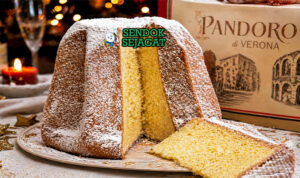 Kue pandoro berbentuk bintang berwarna keemasan dengan tekstur lembut, ditaburi gula halus putih seperti salju, tampilan elegan khas Italia
