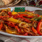 Peperonata khas Italia dengan potongan paprika merah, kuning, dan hijau yang tampak lembut dan mengilap, bercampur saus tomat ringan dan minyak zaitun dalam mangkuk rustic