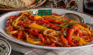 Peperonata khas Italia dengan potongan paprika merah, kuning, dan hijau yang tampak lembut dan mengilap, bercampur saus tomat ringan dan minyak zaitun dalam mangkuk rustic