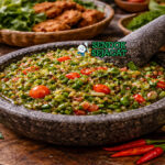 Sambal cibiuk khas Garut dengan cabai merah, bawang, dan terasi yang dihaluskan kasar, disajikan di cobek bersama nasi putih dan ikan goreng