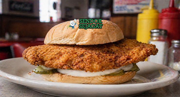 Sandwich dengan daging tenderloin goreng berukuran besar, roti bun, selada segar, dan saus creamy yang menggoda