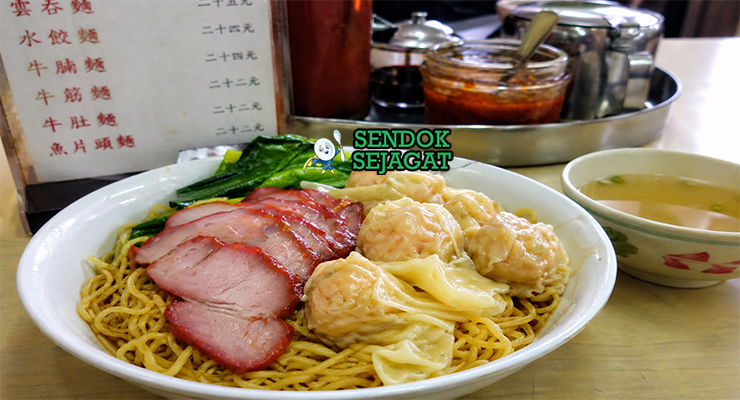 Mi tipis berwarna kuning dengan pangsit udang dalam kuah jernih, dilengkapi sayuran hijau dan topping daging